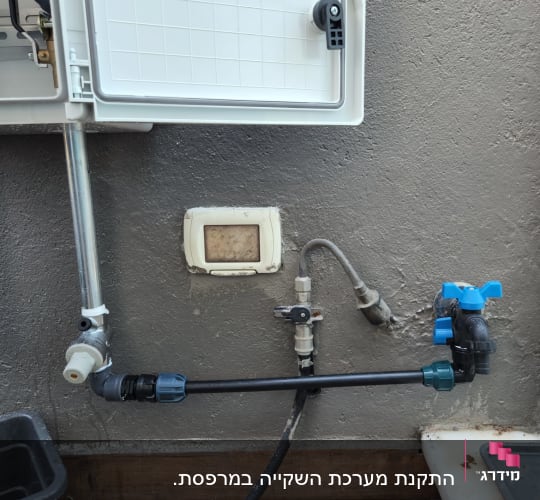 מערכת השקיה עם צינורות וברזים לגינון
